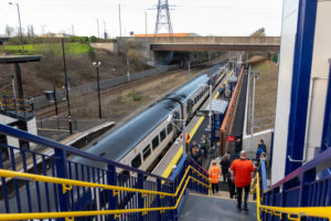 Photo of a Northern train standing at the platform taken from the top of the overbridge. Behind the train, the Metro platform is just visible.